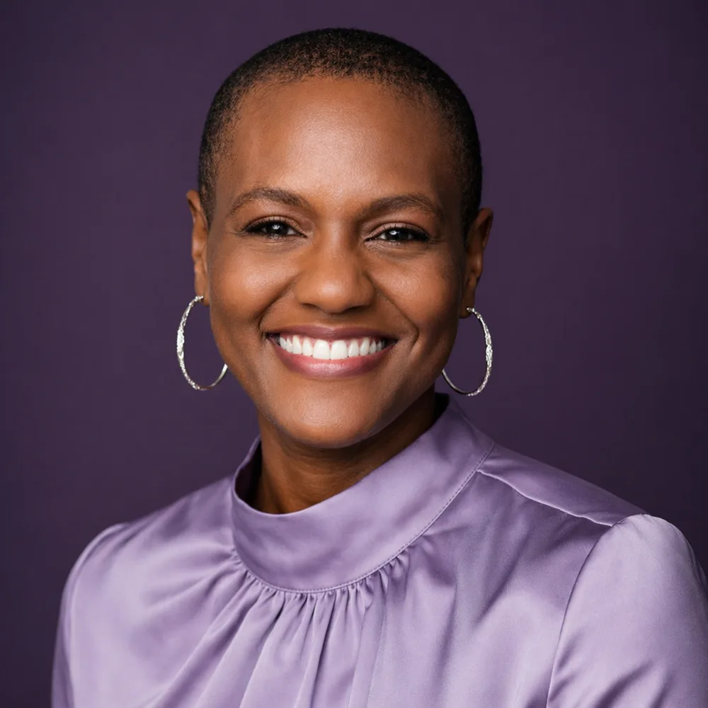 Celeste Angelic London, smiling, in a lavender top against a plum background
